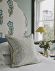 Firmdale Hotel bedroom suite featuring Tasha’s Trip floral upholstered headboard and Mille Feuilles pale blue cushion. Soft grey, blue, white, and yellow interior scheme creating a light, fresh, and elegant atmosphere.